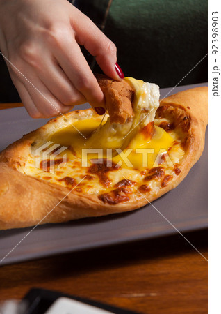 the girl eats traditional Georgian pastries-khachapuri. close-up the girl eats traditional Georgian pastries-khachapuri. close-up 92398903