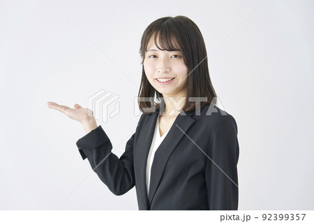 白背景で右側を掌で指すビジネスウーマン 92399357