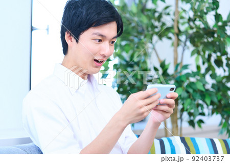 男性　スマホ　リビング　 92403737