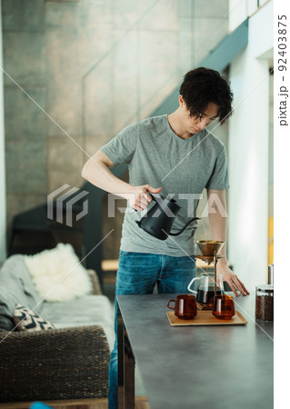コーヒーを淹れる若い男性 92403875