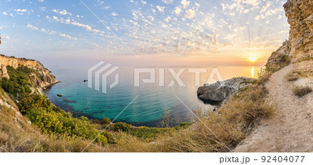 panorama on sunset time with beautiful clouds in the rocky bay with crystal clear azure sea on a sunny day. The concept of an ideal place for summer travel and relaxation. 92404077