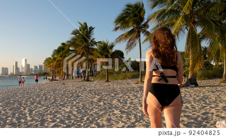 Young woman wearing a bikini at the beach on sunset over Miami 92404825