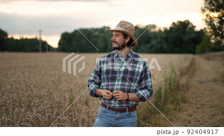 Young farmer, business owner looks at the camera in the field Young farmer, business owner looks at the camera in the field 92404917