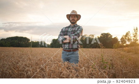 Cheerful and happy young man farmer in hat and plaid shirt smiling positively Cheerful and happy young man farmer in hat and plaid shirt smiling positively 92404923