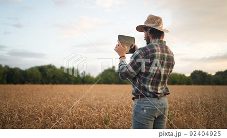 Farmer working with tablet computer on wheat field Farmer working with tablet computer on wheat field 92404925