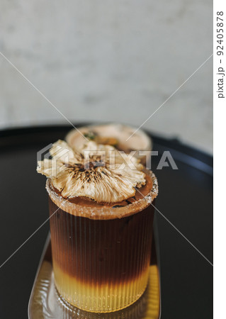 Two iced orange coffee special drinks served on black table in the cafe. 92405878
