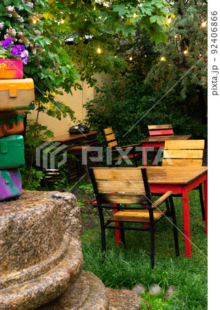 Wooden tables and chairs. Interior of the cafe. interior Street cafe. Cozy street with flowers and French-style cafe table. Decor facade of coffeehouse. Wooden tables and chairs. Interior of the cafe. interior Street cafe. Cozy street with flowers and French-style cafe table. Decor facade of coffeehouse. 92406866