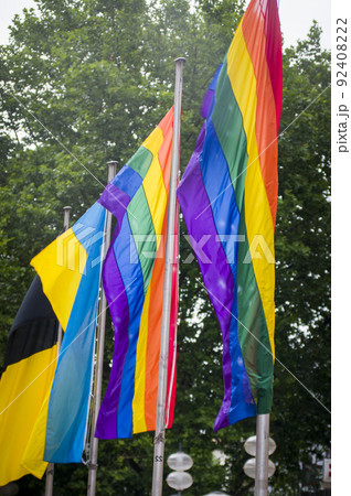 Close Up rainbow gay pride flag outside on a street. Symbol of the Lesbian Bisexual Transgender LGBT community waving in wind against cloudy sky. Social movement for freedom and equliaty. Copy Space 92408222