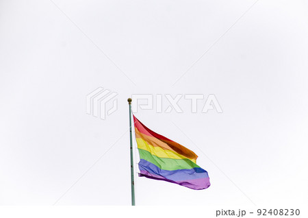 Close Up rainbow gay pride flag outside on a street. Symbol of the Lesbian Bisexual Transgender LGBT community waving in wind against cloudy sky. Social movement for freedom and equliaty. Copy Space Close Up rainbow gay pride flag outside on a street. Symbol of the Lesbian Bisexual Transgender LGBT community waving in wind against cloudy sky. Social movement for freedom and equliaty. Copy Space 92408230