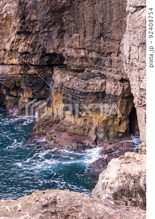 Vibrant turquoise ocean waves crash against the rocks Vibrant turquoise ocean waves crash against the rocks 92408754