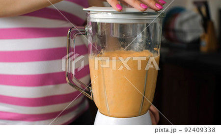 Close-up of Pregnant Woman Preparing Healthy Smoothie Drink from Carrot, Oranges and Apples with Blender Close-up of Pregnant Woman Preparing Healthy Smoothie Drink from Carrot, Oranges and Apples with Blender 92409338
