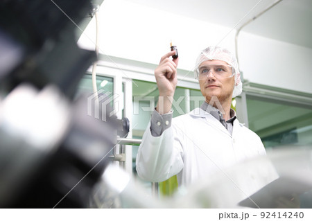 scientist  analyzing a biological and ecological hemp plant used for herbal pharmaceutical CBD oil and THC oil in a laboratory. 92414240