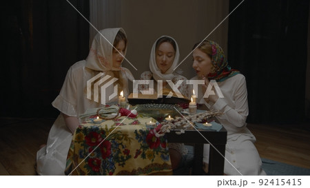 4K. Slavic women fortune-telling in a dark room by candlelight 4K. Slavic women fortune-telling in a dark room by candlelight 92415415