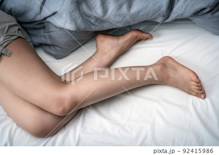 ベッドで寝る女性の素足 92415986