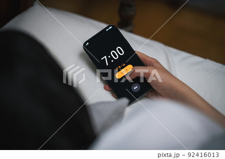 スマホのアラームを止める女性 スマホのアラームを止める女性 92416013