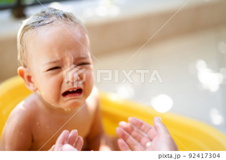Little girl crying in a bowl of water Little girl crying in a bowl of water 92417304