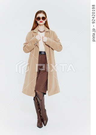 A red-haired lady in a coat on a white background. Full-length shot A red-haired lady in a coat on a white background. Full-length shot 92420198