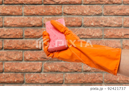Woman's hand in protective glove with sponge. Woman's hand in protective glove with sponge. 92421737