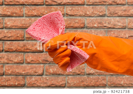 Woman's hand in protective glove with sponge. Woman's hand in protective glove with sponge. 92421738