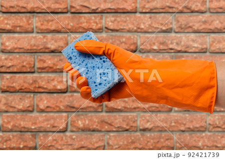 Woman's hand in protective glove with sponge. Woman's hand in protective glove with sponge. 92421739