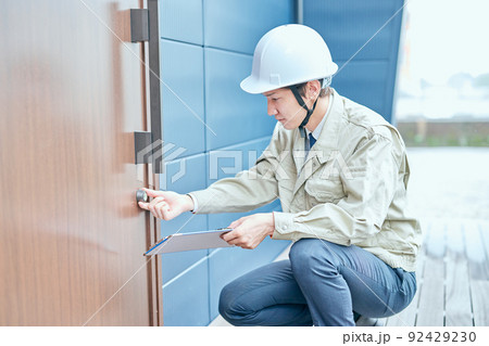 ドアをチェックする作業服姿の若い男性 ドアをチェックする作業服姿の若い男性 92429230