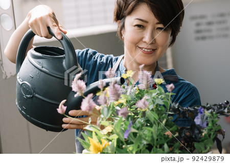 寄せ植え・ガーデニング・花の水やりをする女性 寄せ植え・ガーデニング・花の水やりをする女性 92429879