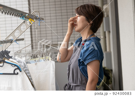 家事をしながら疲労を感じる更年期の女性 家事をしながら疲労を感じる更年期の女性 92430083