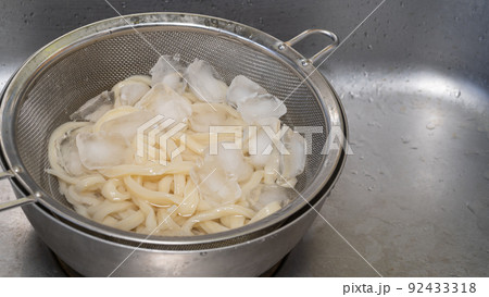茹でたうどんを氷水で冷やす 92433318