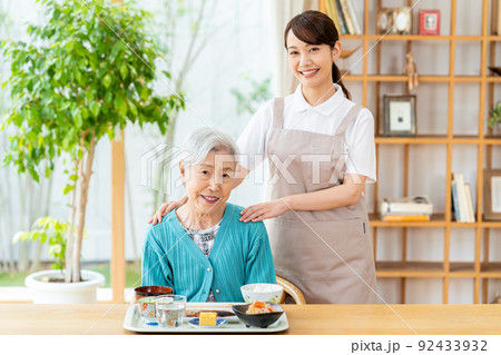 食事するシニア女性とヘルパーの女性 食事するシニア女性とヘルパーの女性 92433932