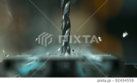 Drill bit drilling into aluminium pipe, macro shot. 92434559