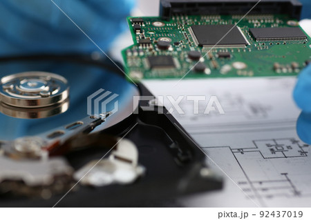Male technician hold computer details, try to fix or collect device, dvd disc Male technician hold computer details, try to fix or collect device, dvd disc 92437019