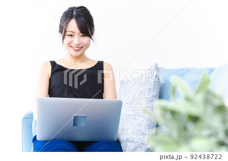 笑顔でパソコンを使う若い女性 笑顔でパソコンを使う若い女性 92438722