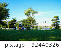 晴天の公園で椅子に座り空を見上げる女性 92440326
