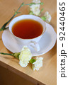 白い花とティーカップに入った紅茶 92440465