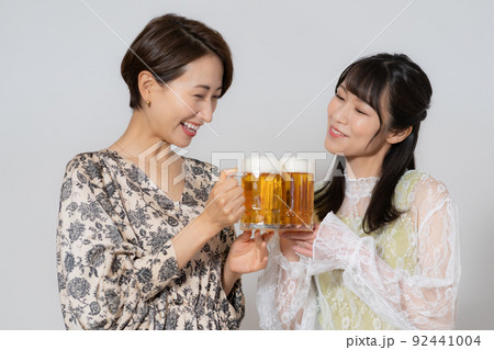 白背景のビールを飲むミドルエイジの女性2人 92441004