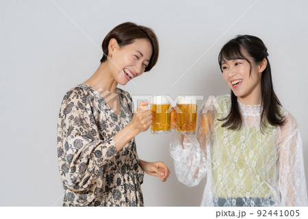 白背景のビールを飲むミドルエイジの女性2人 92441005