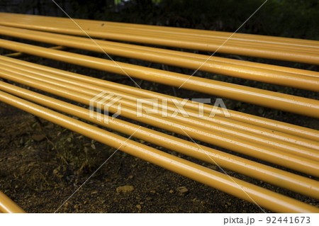 Yellow pipes. Gas pipes lie in row. Preparation of equipment replacement. 92441673