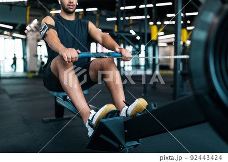 Motivated Black Male Athlete Training On Rowing Machine At Gym Motivated Black Male Athlete Training On Rowing Machine At Gym 92443424