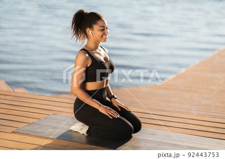 Peaceful african american woman meditating on the beach 92443753