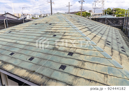 築25年の一戸建ての、色あせて汚くなった屋根の葺き替え工事をするために足場を立てたところ 築25年の一戸建ての、色あせて汚くなった屋根の葺き替え工事をするために足場を立てたところ 92444182