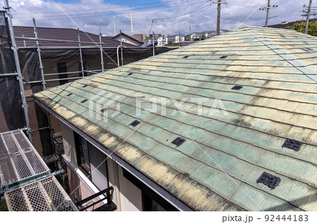 築25年の一戸建ての、色あせて汚くなった屋根の葺き替え工事をするために足場を立てたところ 築25年の一戸建ての、色あせて汚くなった屋根の葺き替え工事をするために足場を立てたところ 92444183