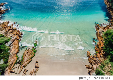 Beach, rocks and blue ocean in Brazil. Aerial view of tropical beach in Florianopolis Beach, rocks and blue ocean in Brazil. Aerial view of tropical beach in Florianopolis 92446183