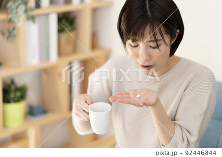 薬を飲む若い女性 92446844
