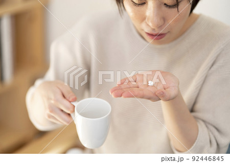 薬を飲む若い女性 92446845