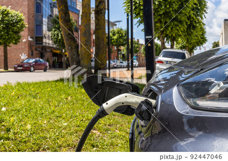 Electric vehicle or EV car with the power cable supply plugged in 92447046