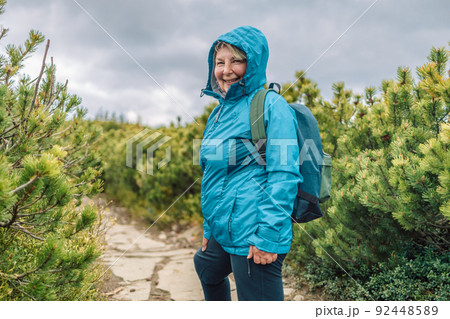 Happy 50s woman Traveler going mountains landscape on background. Travel Lifestyle concept. Adventure summer vacations Happy 50s woman Traveler going mountains landscape on background. Travel Lifestyle concept. Adventure summer vacations 92448589