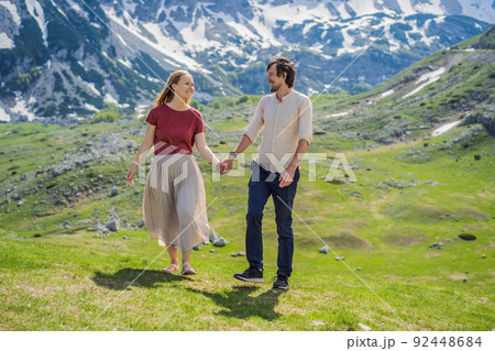 Couple tourists man and woman in Mountain lake landscape on Durmitor mountain in Montenegro beautiful Durmitor National park with lake glacier and reflecting mountain Portrait of a disgruntled girl 92448684