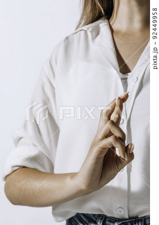 woman in shirt praying with crossed fingers over white background woman in shirt praying with crossed fingers over white background 92449958