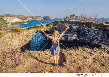 Young woman tourist near Broken Beach in Nusa Penida, Indonesia Angel's BillaBong Beach. Popular tourist destination Bali 92450425