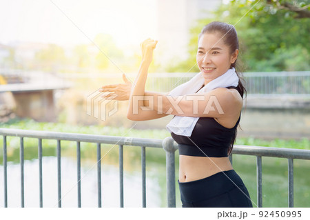 Asian healthy woman shoulder Stretching exercise at park outdoor morning 92450995